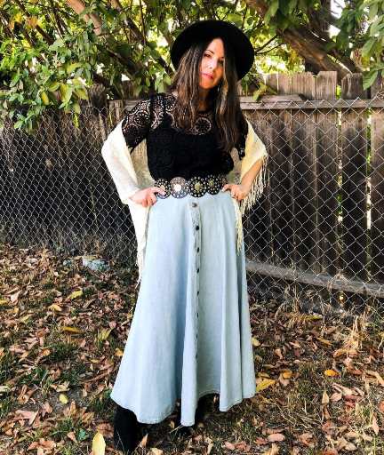 woman wearing A light blue button-down denim maxi skirt paired with a black crochet top